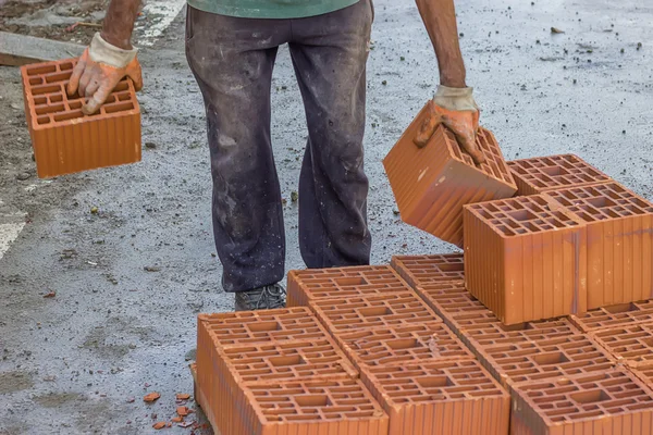 Builder worker carrying hollow clay block