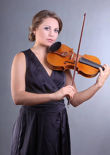 A charming young girl playing the violin professionally