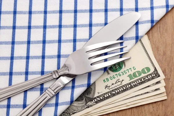 Fork and knife on dollar bills