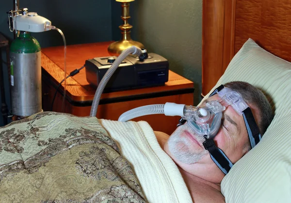 Senior Adult Wearing CPAP in Bed with Oxygen