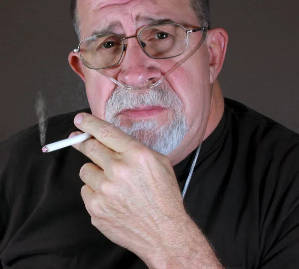Adult Man Smoking While Wearing Oxygen Cannula