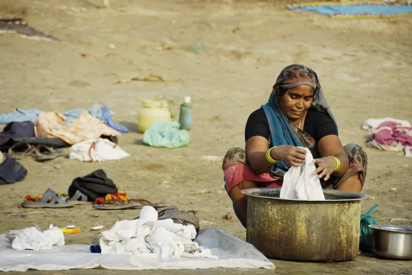 Indian woman washes clothes in Ganga river in Varanasi, India.