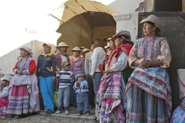 Quechua women watch traditional dance at harvest celebration in Chivay village, Arequipa region, Peru.