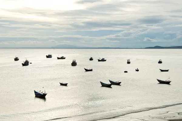 Boats silhouettes in a fishing harbour in Mui Ne, Vietnam.