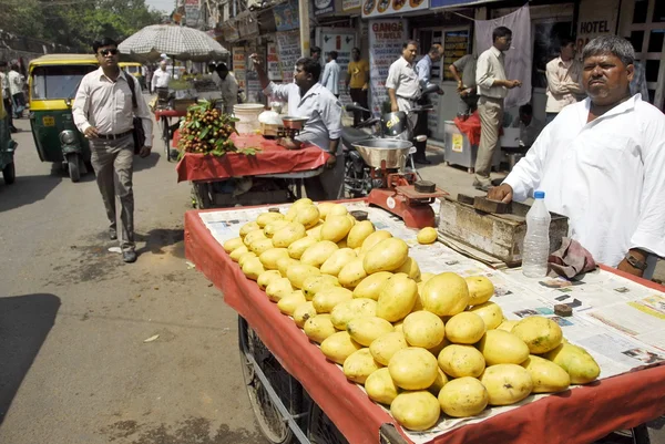 Indian street vendor sells mangoes on a Main Bazaar street in New Delhi, India.