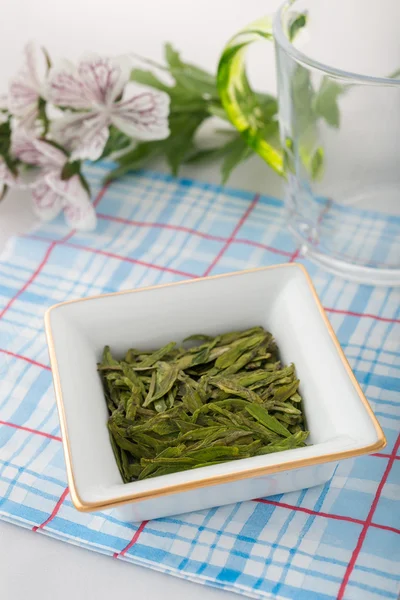 Loose green tea leaves with flowers