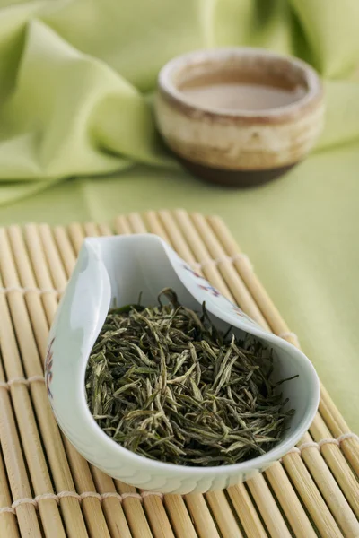 Green tea leaves and tea in teacup