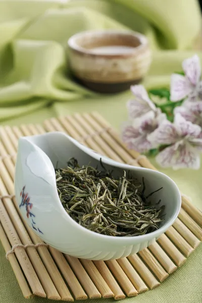 Green tea dry leaves, tea infusion and flowers
