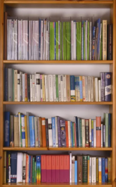 Blurred bookshelf with books and magazines
