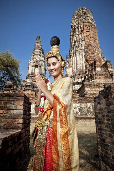Woman performing typical thai dance with thai style temple background