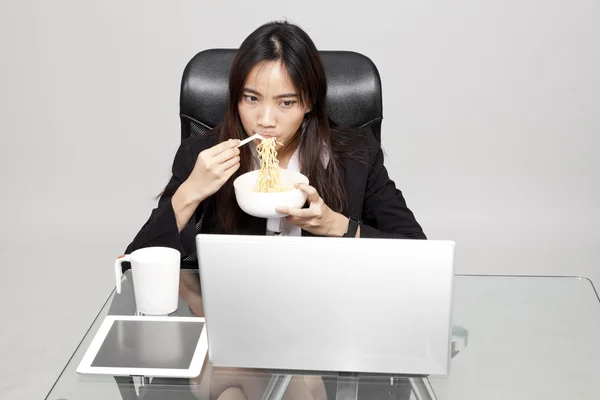Woman worker eating unhealthy food during the office hour.