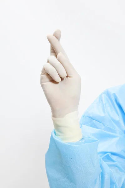 Closeup Portrait of female doctor-crossed fingers over white background