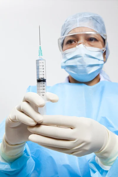 A medical doctor preparing an injection in a syringe