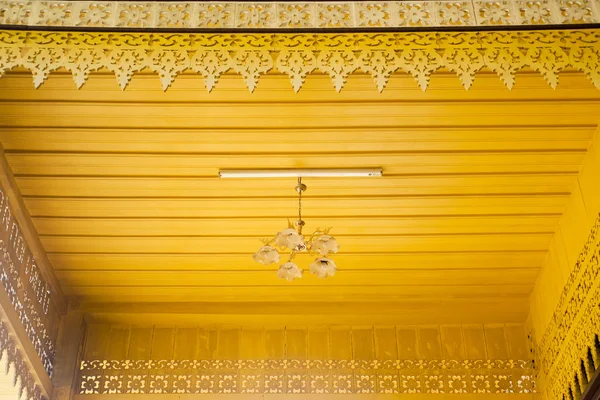 The ceiling is decorated in traditional Thai temple