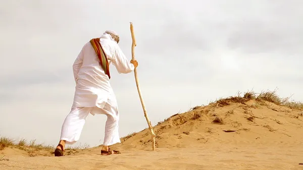 Middle Eastern Man Walking in Desert