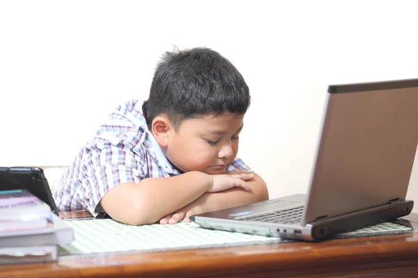 Asian boy playing computer and feel sleepy