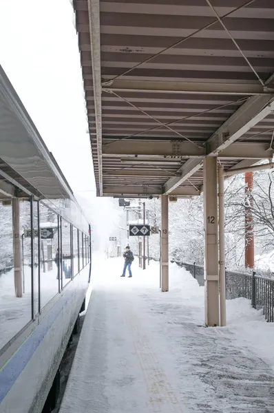 Railway station view with train and one man , snowing in winter
