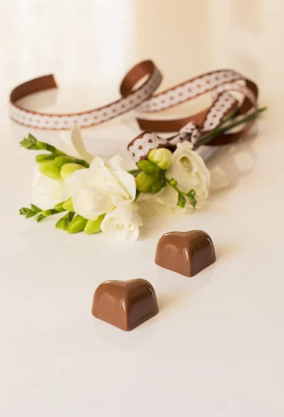 Sprig of freesia flower and chocolates