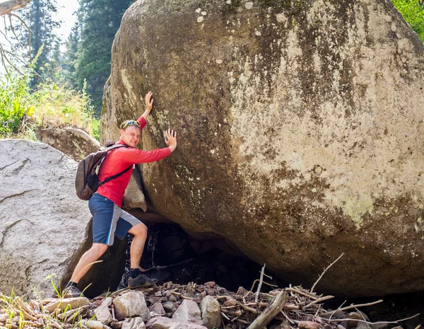 Man pushing a huge rock