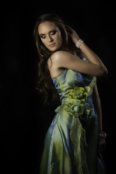 Sensual brunette woman in green evening dress