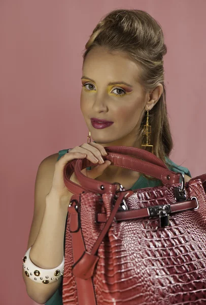 Beautiful blonde pin up woman with pink handbag