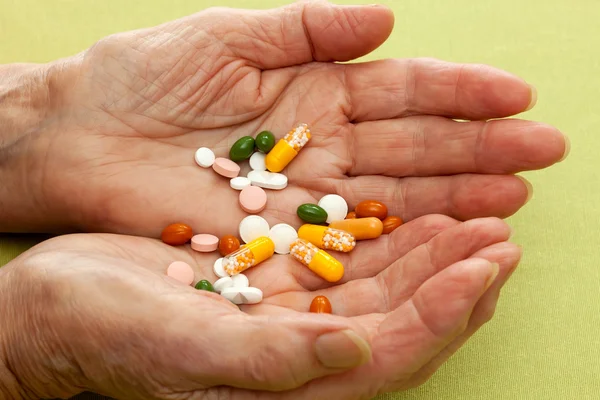 Cupped hands of an old lady with a cocktail of tablets