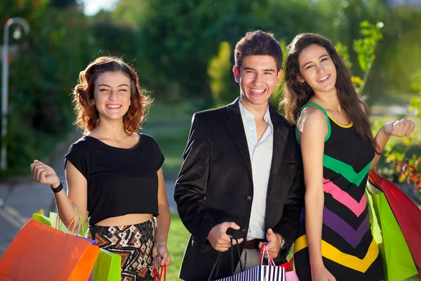 Three stylish teenagers out shopping together.