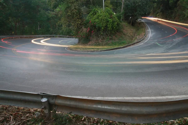 Sharp curve road with car light line