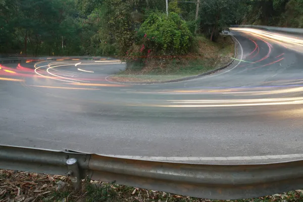 Sharp curve road with car light line