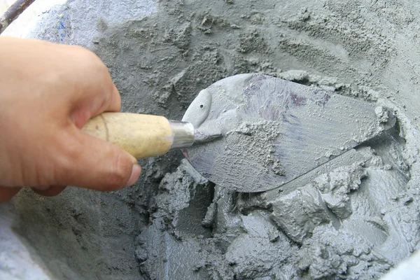 Applying construction trowel in wet cement