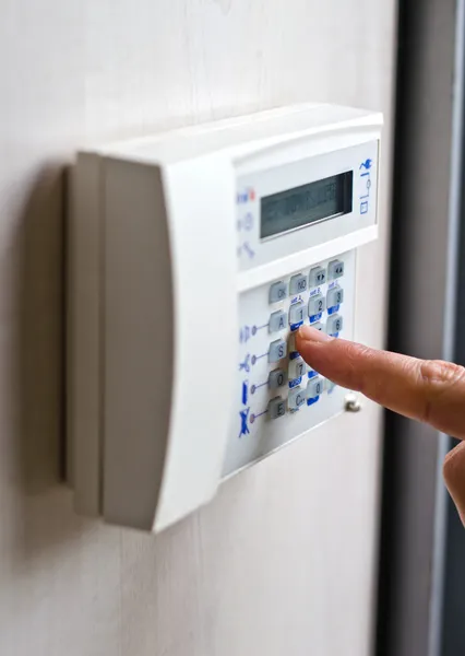 Finger pressing keys on alarm keypad