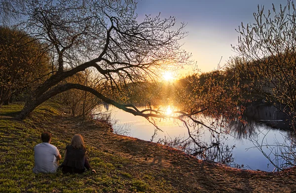 People sitting on the banks of the river