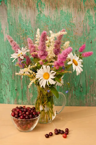 Still life bouquet of chamomiles and astilbe with gooseberries