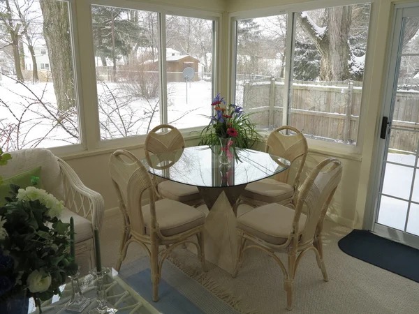 Decorated Florida Room with vase of flowers with fresh white snow in background