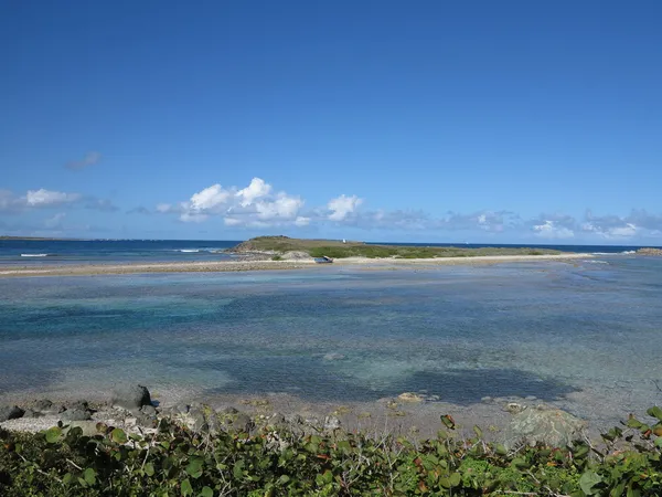 Looking out towards the Atlantic Ocean with barrier islands and sand bars seen at low tide from the nature preserve near Orient Beach in St. Martin