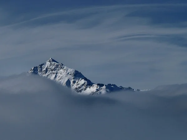 Alp peak in winter, mist, fog and smog.