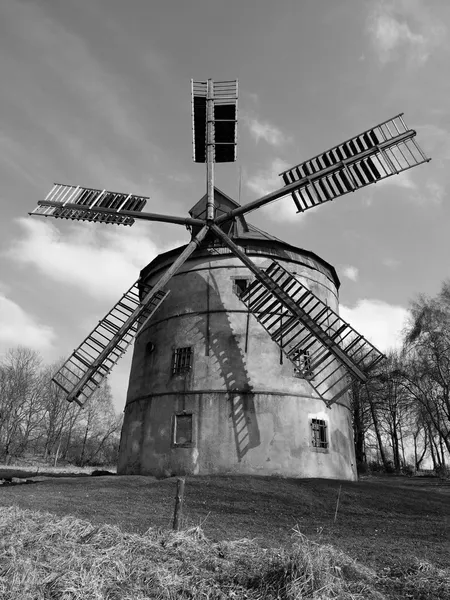 Renewal wind mill house into summer house. New red roof, repaired wind blades. Black and white photo.