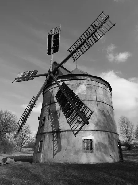 Renewal wind mill house into summer house. New red roof, repaired wind blades. Black and white photo.