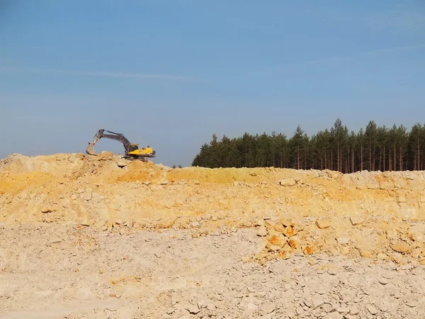 Big black orange digger in open sand mine is waiting for new shift.