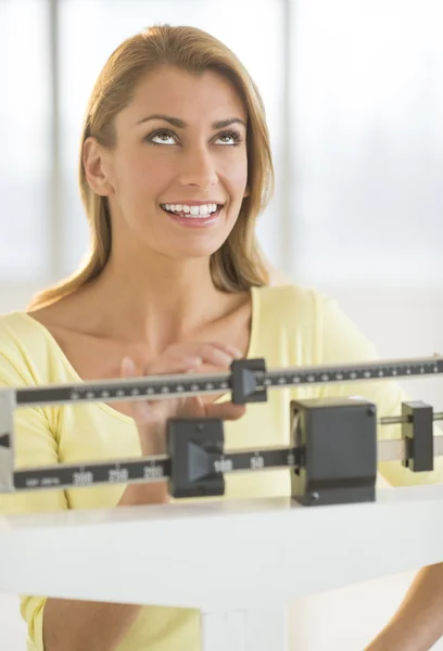 Happy Woman Looking Up While Using Balance Weight Scale