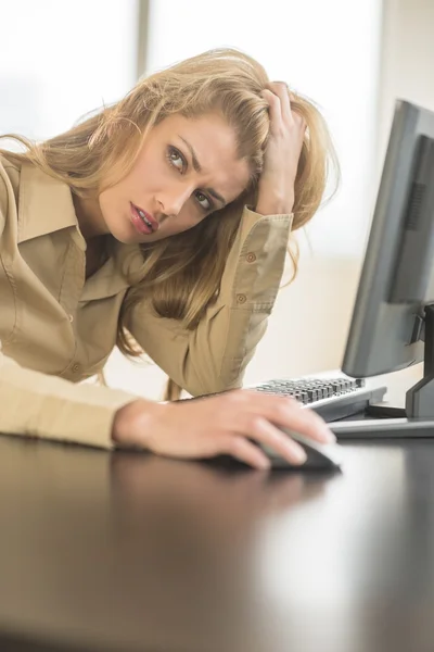 Tired Businesswoman Looking Away While Sitting At Computer Desk