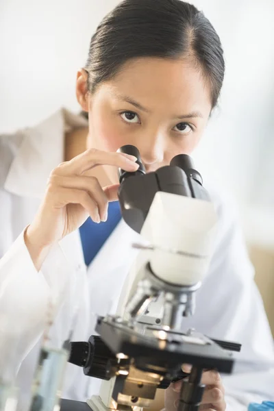 Portrait Of Female Scientist Using Microscope