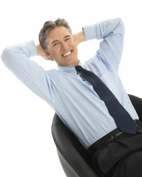 Portrait Of Happy Businessman Relaxing On Office Chair