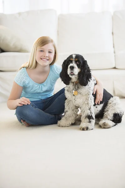 Cute Girl Sitting With Pet Dog In Living Room
