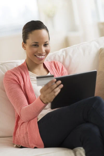Woman With Credit Card Shopping On Digital Tablet At Home
