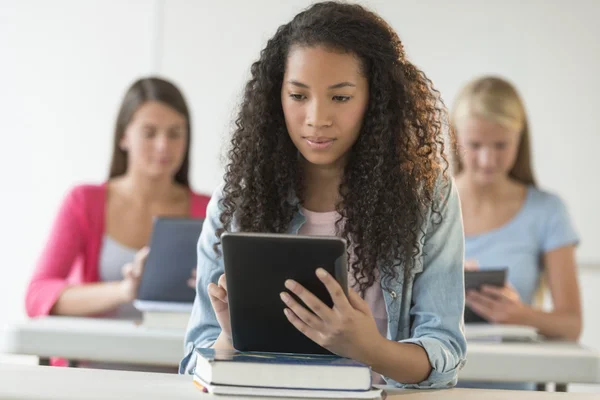 Female Students Using Digital Tablet At Desk