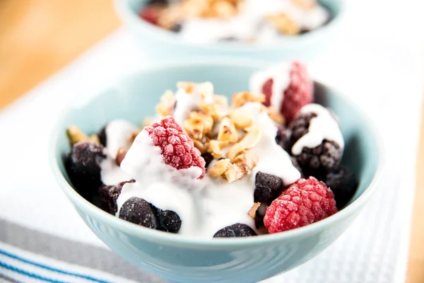 Healthy Paleo Style dessert, Frozen Berries in Coconut Milk with Nuts on Top