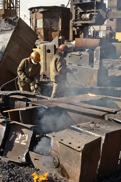 Workers melting metal