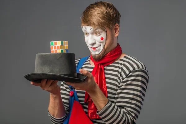 Clown looking at Rubik's Cube