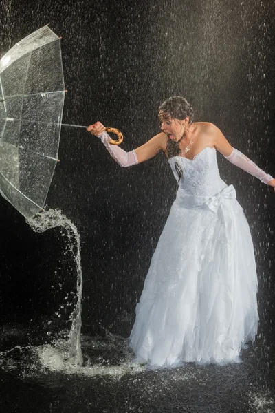 Bride standing under rain
